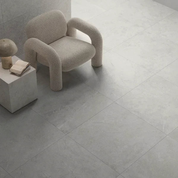 Commercial flooring supplies showcasing large-format matte grey porcelain or ceramic floor tiles in a minimalist interior setting.
